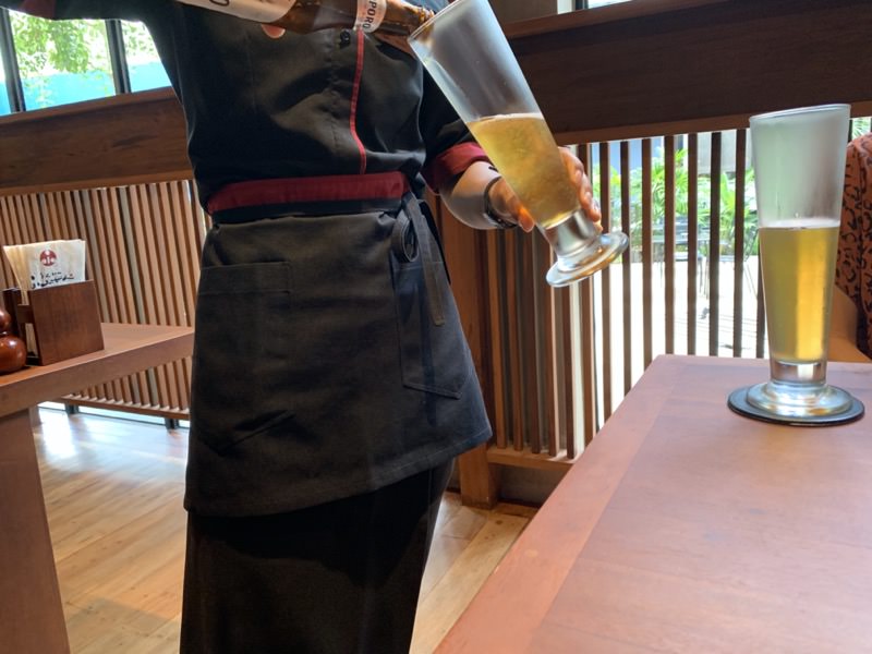 ビールを注いでくれるシェムリアップのとんかつふみぜんのスタッフ